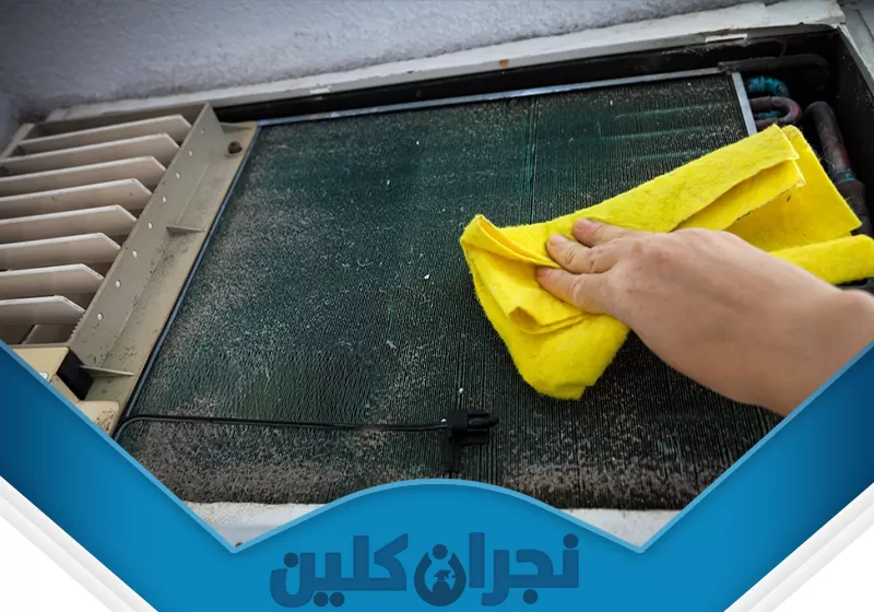 صيانة مكيفات فلبيني بنجران 0566353695 نجران كلين تُظهر الصورة فنيًا من شركة نجران كلين ينظف زعانف المبخر بمكيف سبليت بقطعة قماش لإزالة الأتربة، ما يعزز كفاءة التبريد ويضمن هواءً نقيًا واستهلاك طاقة أقل.