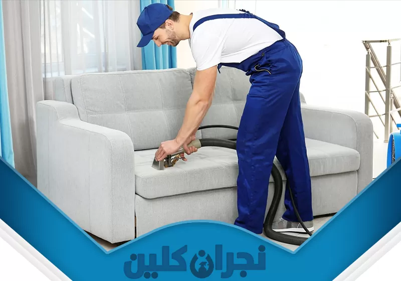 تنظيف الكنبات من الغبار بنجران 0566353695 نجران كلين تُظهر الصورة عاملًا يقوم بتنظيف الكنبات باستخدام مكنسة كهربائية، مما يعكس خدمة تنظيف الكنبات من الغبار بنجران. حيث يعمل بدقة لإزالة الأتربة والشوائب من قماش الأريكة، مما يضمن بيئة نظيفة وصحية.